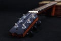 Tuning pegs on wooden machine head of six strings acoustic guitar neck on black background Royalty Free Stock Photo