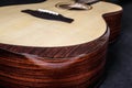 Tuning pegs on wooden machine head of six strings acoustic guitar neck on black background