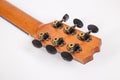 Tuning pegs on wooden machine head of six strings guitar on white background