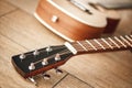 Tuning sound. Close view of guitar neck with tuning keys for adjusting guitar strings lying on the wooden floor Royalty Free Stock Photo