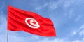 Tunisia flag on flagpole on blue sky background. Tunisian flag fluttering in wind against a sky with white clouds. Place for text