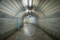 Tunnel of empty futuristic underpass with a smooth turn, lined with marble tiles