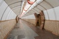 Tunnel of empty heptagonal long futuristic underpass, lined with brown marble and ceramic tiles