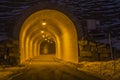 Tunnel entrance of winter mountain road illuminated at night Royalty Free Stock Photo