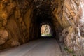 Tunnel and road curving through red rock sandstone