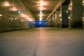 Tunnel underground pedestrian crossing at dusk with burning lights from the lower angle