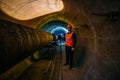 Tunnel worker examines pipeline in underground tunnel