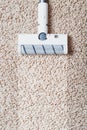 The turbo brush of a cordless vacuum cleaner cleans the carpet in the house With a clean stripe Royalty Free Stock Photo