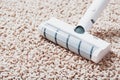 The turbo brush of a cordless vacuum cleaner cleans the carpet in the house in close-up Royalty Free Stock Photo