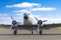 Turbo-prop vintage airplane parked at the airport, shiny metal fuselage aircraft against a background of clouds and a blue sky. Royalty Free Stock Photo