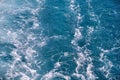 Turbulence made by foam of sea water from a high-speed yacht on surface of sea. Blue sea waves with lot of sea foam. Royalty Free Stock Photo