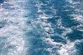 Turbulence made by foam of sea water from a high-speed yacht on surface of sea. Blue sea waves with lot of sea foam. Royalty Free Stock Photo