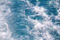 Turbulence made by foam of sea water from a high-speed yacht on surface of sea. Blue sea waves with lot of sea foam. Royalty Free Stock Photo