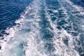 Turbulence made by foam of sea water from a high-speed yacht on surface of sea. Blue sea waves with lot of sea foam. Royalty Free Stock Photo