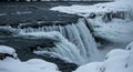 Turbulent River Current Meets Snowy Precipice with Jagged Ice Formations Under Overcast Light Highlighting Dramatic Waterfall Drop Royalty Free Stock Photo