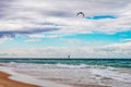 Turbulent sea with wind surfer catching air and helicopter overhead and sailboats on horizon off Gold Coast in Queensland