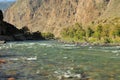 A turbulent stream of a small river with clear water flowing along the bottom of a deep canyon Royalty Free Stock Photo