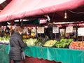 Turin, Italy - february 2021: a woman buys fresh vegetables at the counter of the historic market of Porta Palazzo