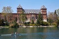 Valentino castle red bricks facade and Po river with people rowing in Piedmont, Turin, Italy