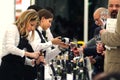 Turin, Piedmont, Italy. -10-26-2009- Fair `Wine show`, female sommelier uncork a bottle of wine to taste.