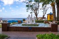 Homeless man sleeps on a bench near a fountain in Alanya park. Houseless in a protective medical Royalty Free Stock Photo