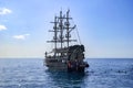 Vintage pirate ship and tourists swimming in the water near it in the Mediterranean in Alanya.