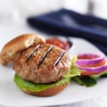 Turkey burger on bun with lettuce and fixings close up