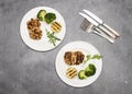 Turkey or chicken cutlets meatballs zucchini and broccoli in white plates on a grey background  top view. Healthy balanced food Royalty Free Stock Photo