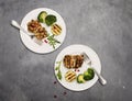 Turkey or chicken cutlets meatballs zucchini and broccoli in white plates on a grey background  top view. Healthy balanced food Royalty Free Stock Photo