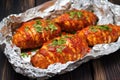 turkey cutlets coated in spicy marinade resting on aluminum foil