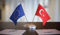 Turkey and EU flags on table. Negotiation between European Union and Turkey. 3D rendered illustration.