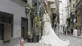 Turkey, Istanbul - July 27, 2022: Young fashionable luxury girl bride in elegant long wedding white dress in the narrow