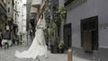 Turkey, Istanbul - July 27, 2022: Young fashionable luxury girl bride in elegant long wedding white dress in the narrow