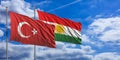 Turkey and Kurdistan flags wave under a blue sky with many white clouds. 3d illustration