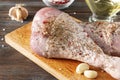 Turkey legs with garlic close up,  pepper , salt  on the kitchen Board, oil on a wooden brown background, raw meat Royalty Free Stock Photo