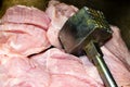 Turkey meat cut into pieces and a hammer for beating the meat. Close-up, surface texture Royalty Free Stock Photo