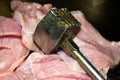 Turkey meat cut into pieces and a hammer for beating the meat. Close-up, surface texture Royalty Free Stock Photo