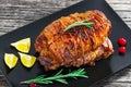 Turkey meat roulade roasted in oven on black rectangular dish