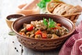 Turkey meat stew with mushrooms and vegetables in ceramic bowl on wooden table