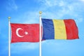 Turkey and Romania two flags on flagpoles and blue cloudy sky