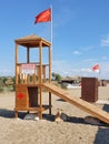 Turkey, Side, November, 2020: On an empty sandy beach under a lifeguard tower with a red flag, goats lie and relax in the shade Royalty Free Stock Photo