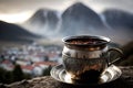 turkih coffee in metal cup, with view of misty mountain range