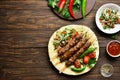 Turkish Adana Kebab with fresh vegetables on flatbread