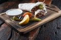 Turkish and Arabic traditional Ramadan Adana kebab roll wrap serving with yogurt and hot pepper on rustic wooden background