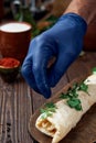Turkish and arabic traditional roll adana kebab with vegetable salad on rustic wooden background. The chef sprinkles the kebab Royalty Free Stock Photo