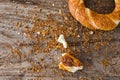 Turkish bagel simit pieces and sesame seeds crumb on wooden background