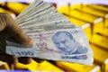 Turkish banknotes on hand golden background