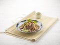 Turkish beef liver Slices in a dish with isolated on wooden mat side view on grey background