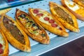 Traditional Turkish pide with various fillings on bakery showcase