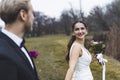 Turkish bride with beautiful smile on her face leading her newlywed husband. Outdoor late autumn photoshoot. Marriage Royalty Free Stock Photo